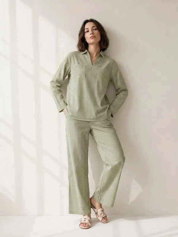 AI-generated catalog image of a woman in a green striped co-ord set against a sunlit studio wall