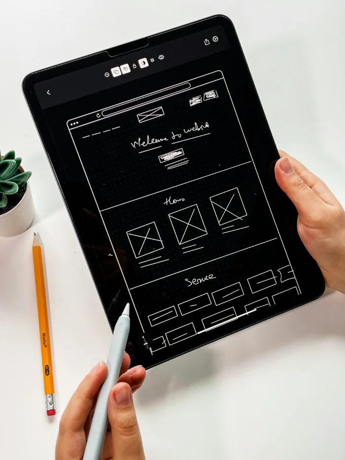 Designer sketching a corporate website wireframe on a tablet