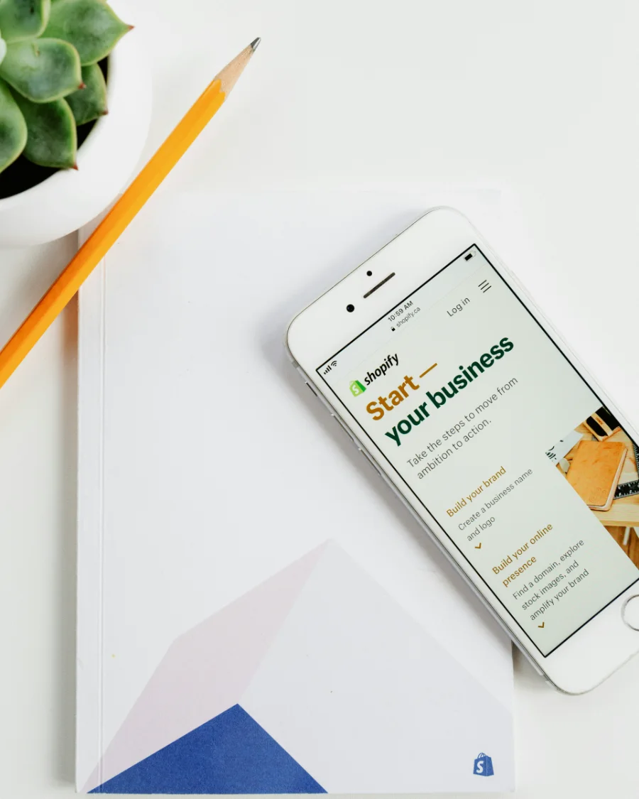 Phone showing a Shopify store page on a desk